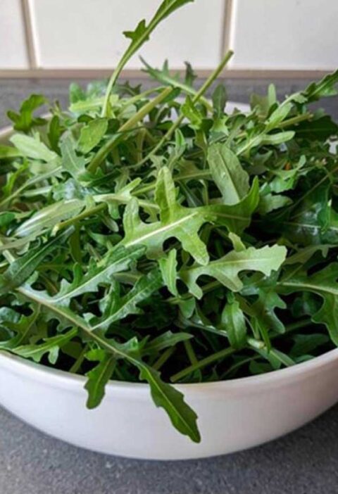 Een wit schaaltje met verse rucola.