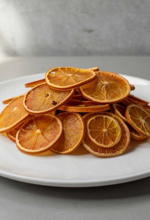 Een bord met daarop schijfjes gedroogde sinaasappel.