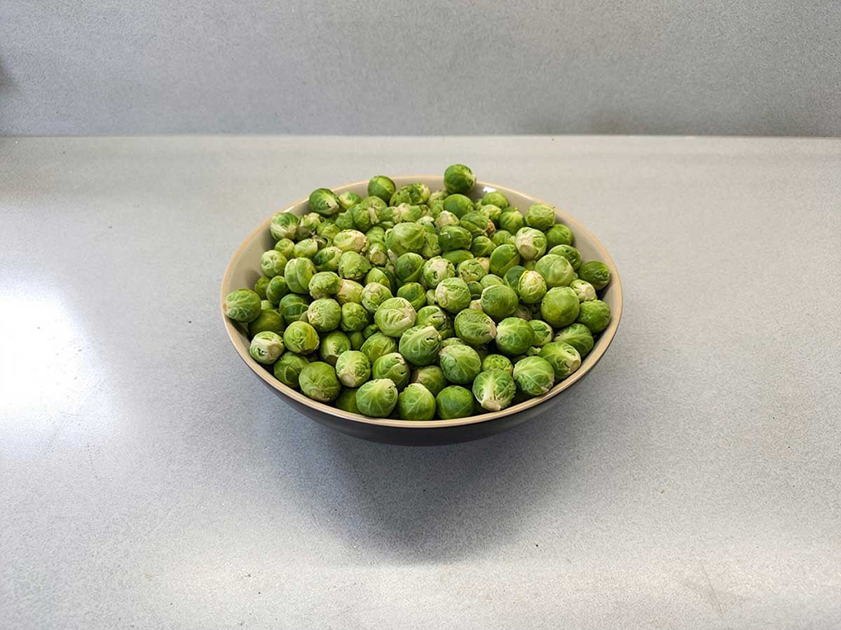 Een grote schaal met verse schoongemaakte spruitjes.