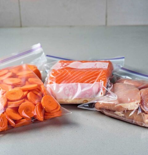 Een vacumeerzak met wortels, met zalm en met kipfilet.