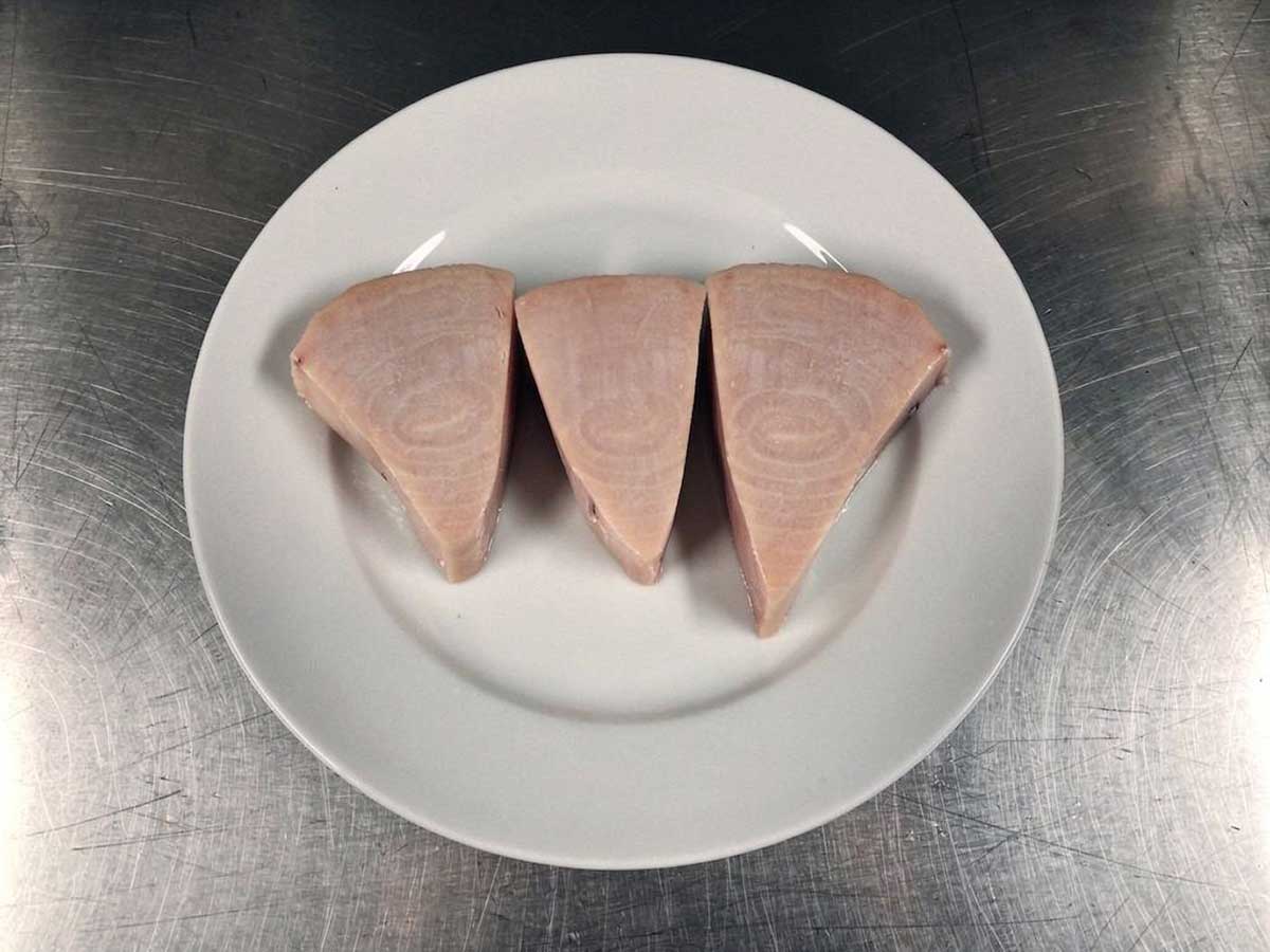 Drie zwaarvisfilets op een wit bord.