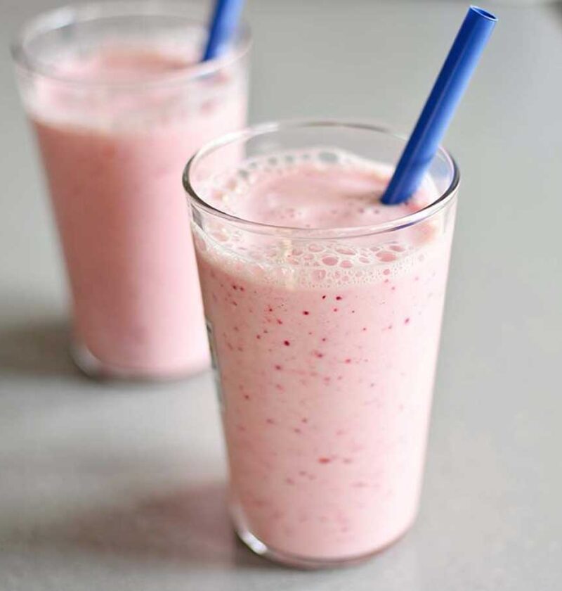 Twee glazen met verse zelfgemaakte aardbei banaan milkshake.