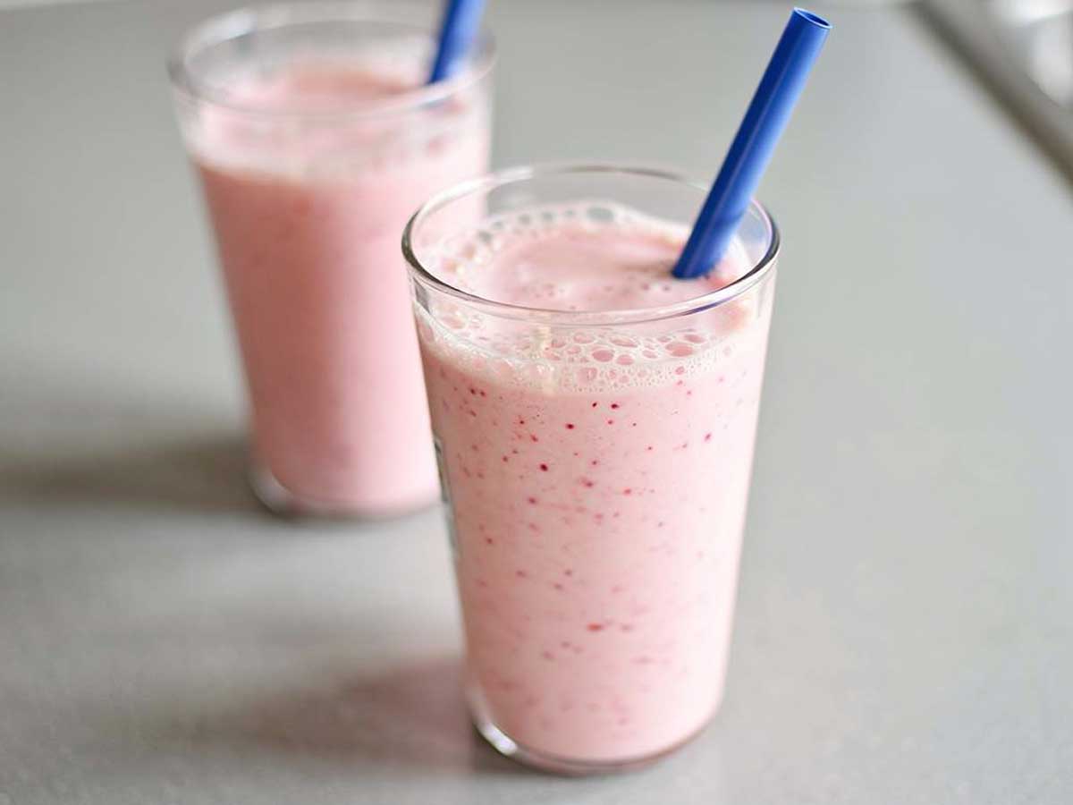 Twee glazen met verse zelfgemaakte aardbei banaan milkshake.