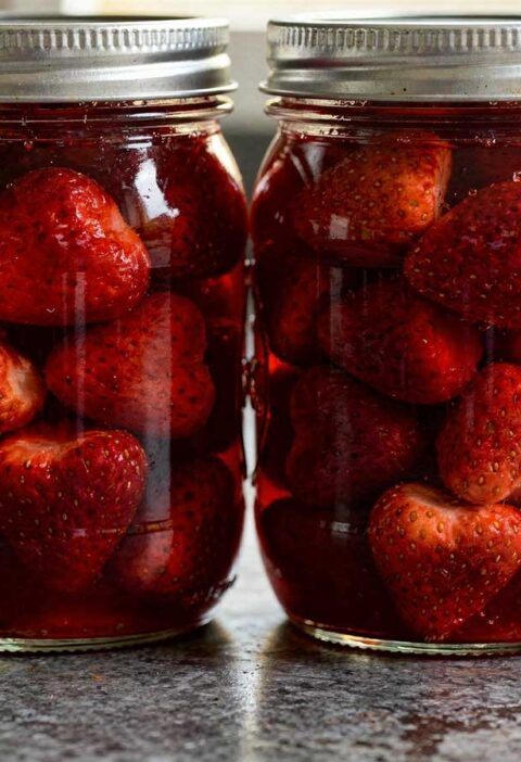 Twee inmaakpotten met ingemaakte aardbeien.
