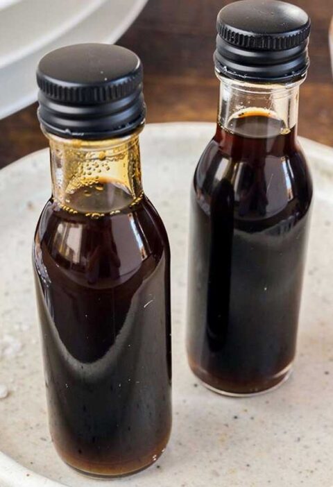 Twee kleine flesjes met daarin zelfgemaakte balsamico vinaigrette.