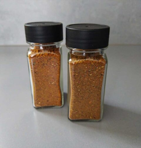 Twee kruidenpotjes, helemaal gevuld met biryani kruiden.