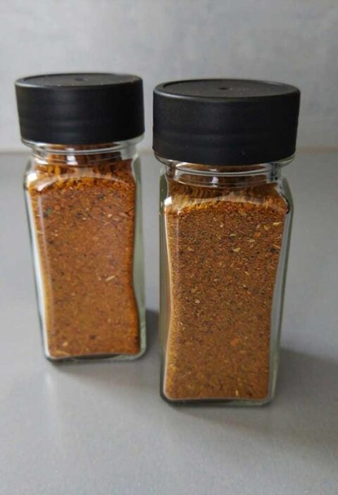 Twee kruidenpotjes, helemaal gevuld met biryani kruiden.