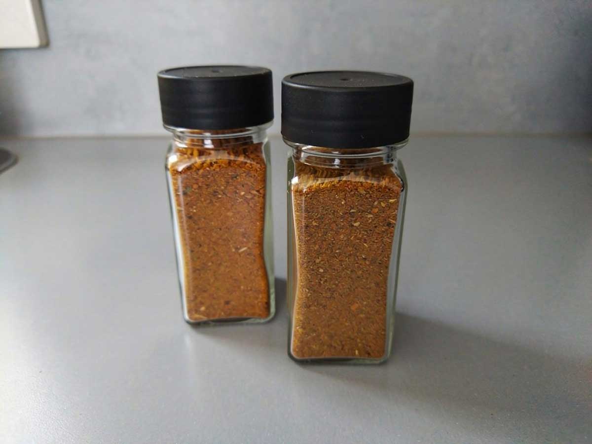 Twee kruidenpotjes, helemaal gevuld met biryani kruiden.