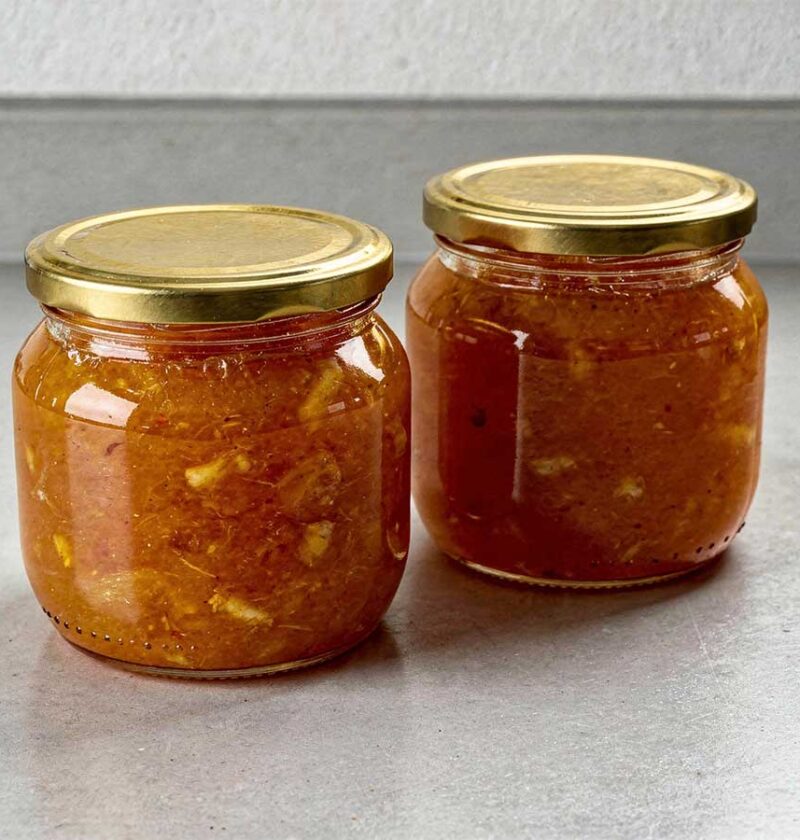 2 grote jampotten die helemaal gevuld zijn met zelfgemaakte bittere sinaasappelmarmelade.