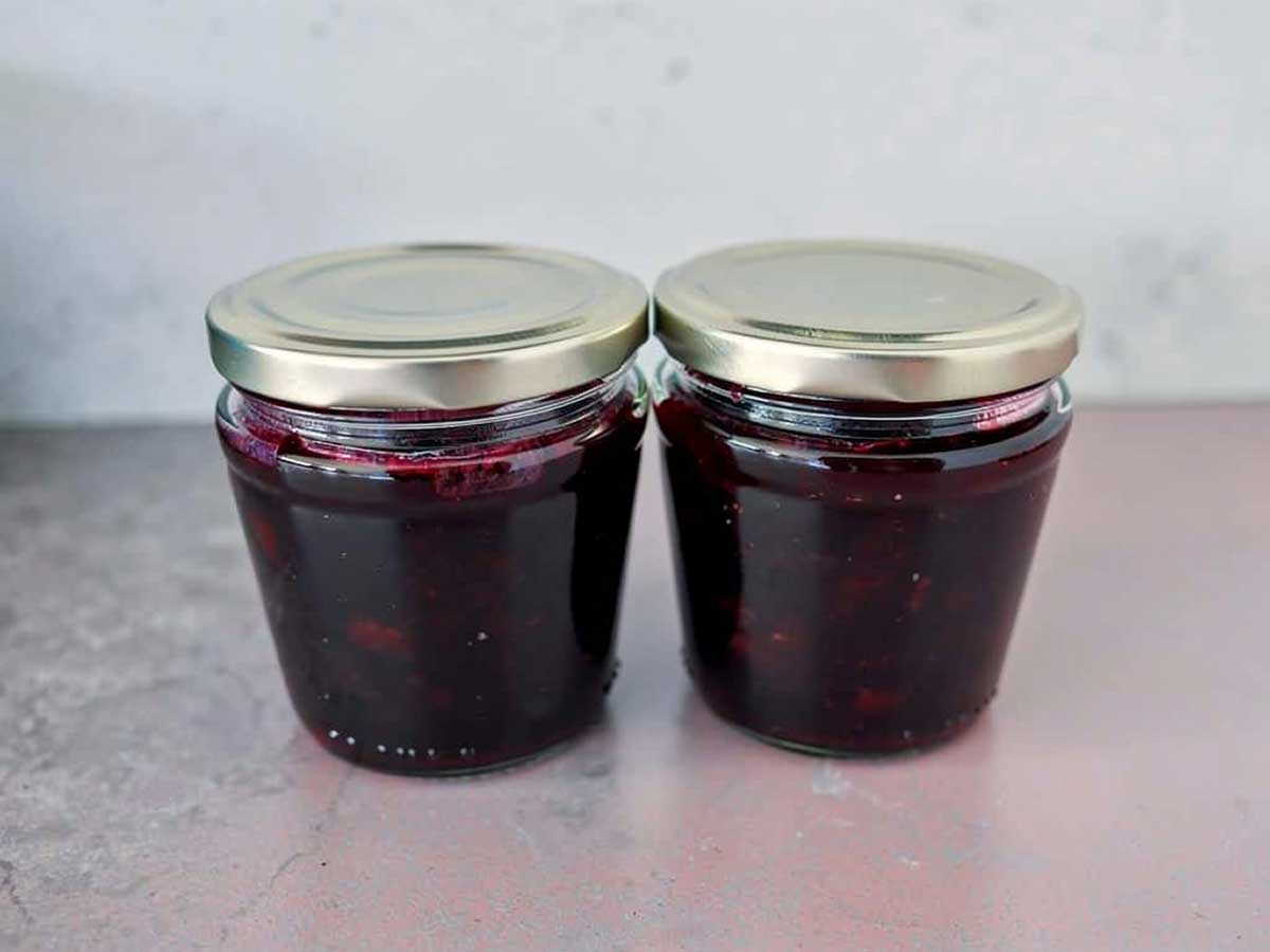 Twee jampotten met daarin blauwe honingbes jam.