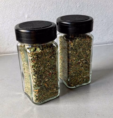 2 kruidenpotjes met boerenkoolkruiden met zwarte deksels.