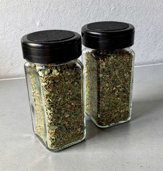 2 kruidenpotjes met boerenkoolkruiden met zwarte deksels.