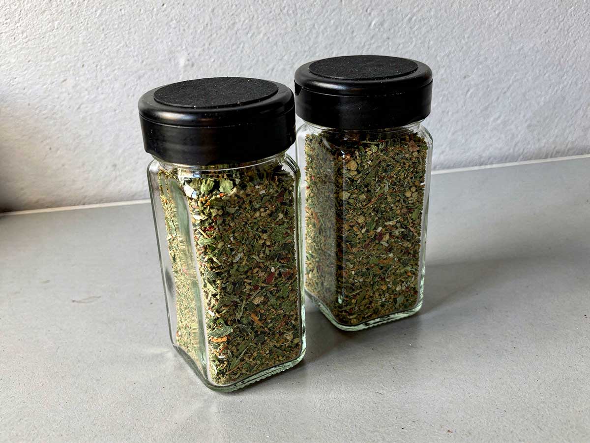 2 kruidenpotjes met boerenkoolkruiden met zwarte deksels.