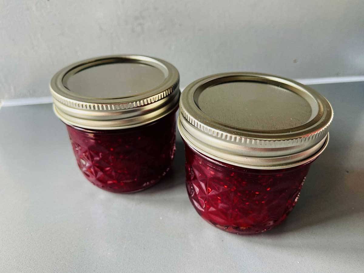 2 jampotjes met daarin zelfgemaakte cranberryjam.