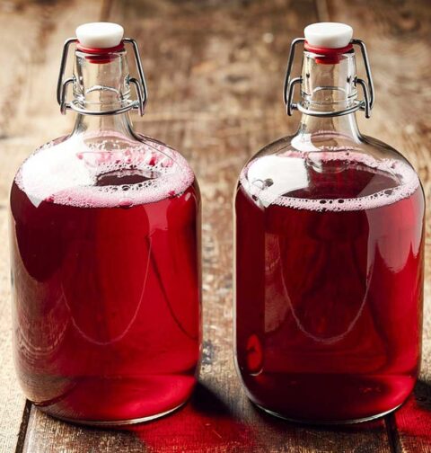 Twee beugelflessen van 1,5 liter met daarin zelfgemaakt cranberrysap.