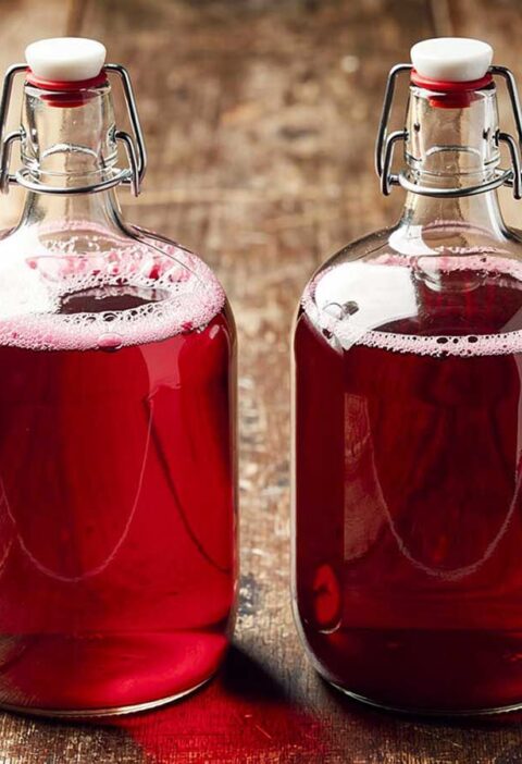 Twee beugelflessen van 1,5 liter met daarin zelfgemaakt cranberrysap.