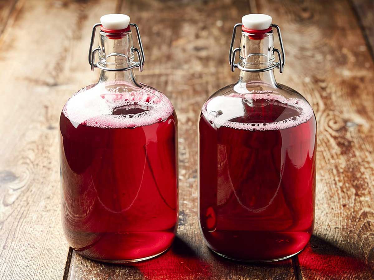 Twee beugelflessen van 1,5 liter met daarin zelfgemaakt cranberrysap.