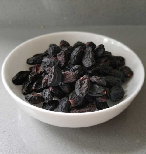 Een schaaltje met gedroogde blauwe druiven.