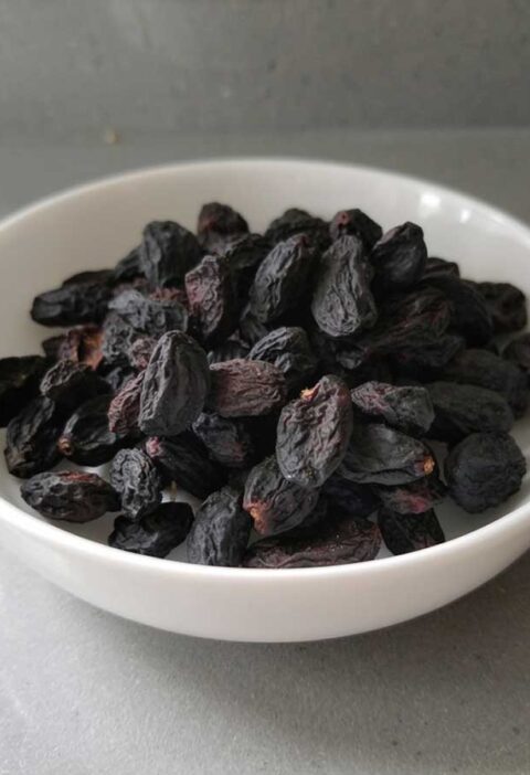 Een schaaltje met gedroogde blauwe druiven.