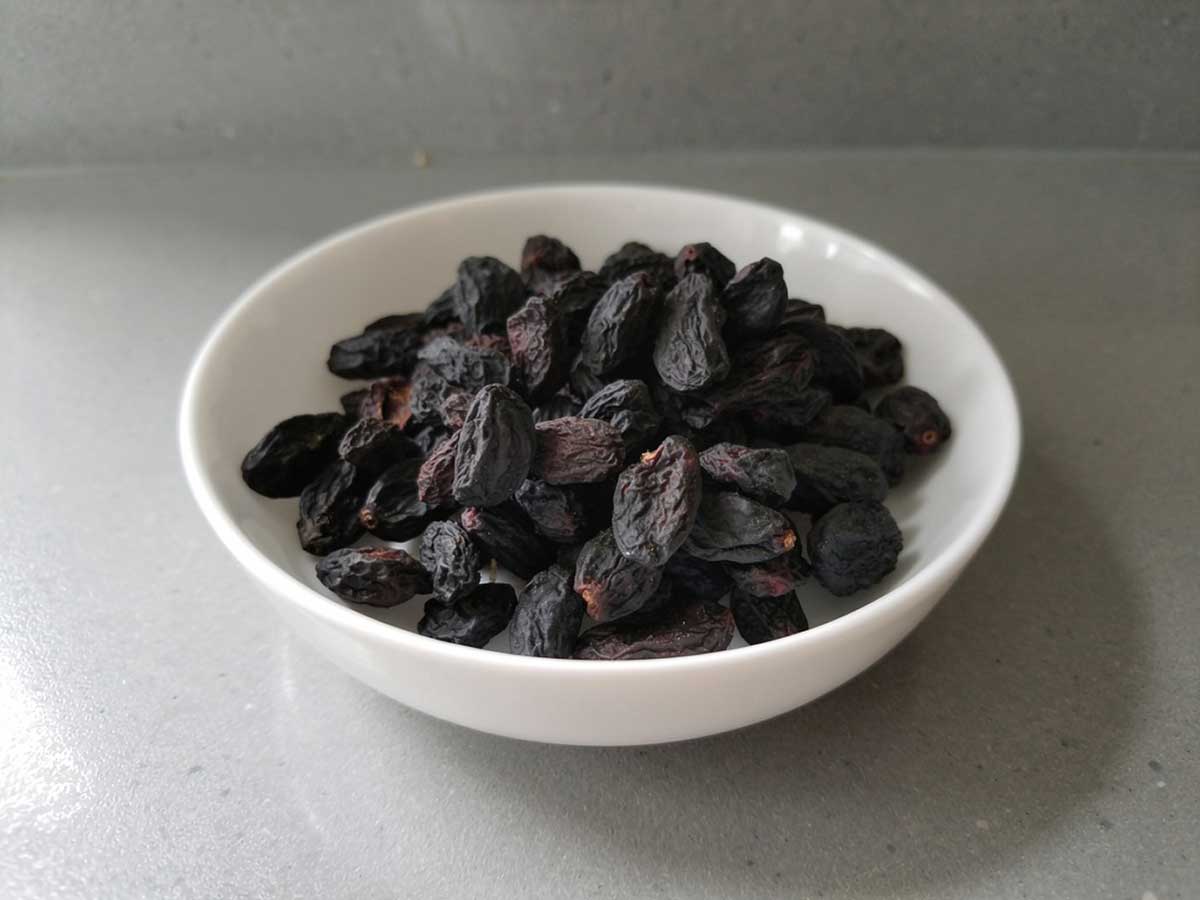 Een schaaltje met gedroogde blauwe druiven.