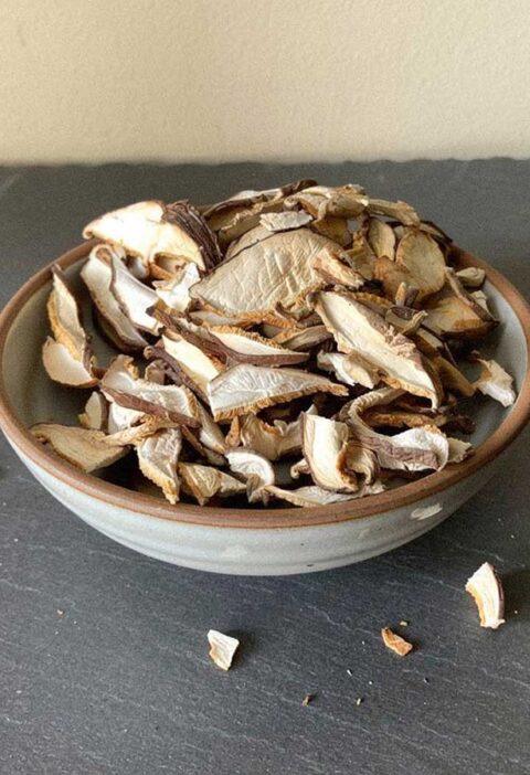 Een schaaltje met daarin gedroogde plakjes en stukjes eekhoorntjesbrood.