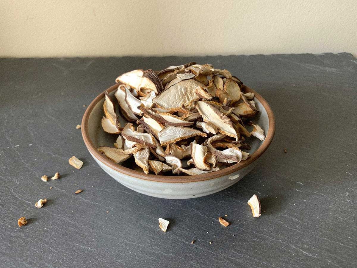 Een schaaltje met daarin gedroogde plakjes en stukjes eekhoorntjesbrood.