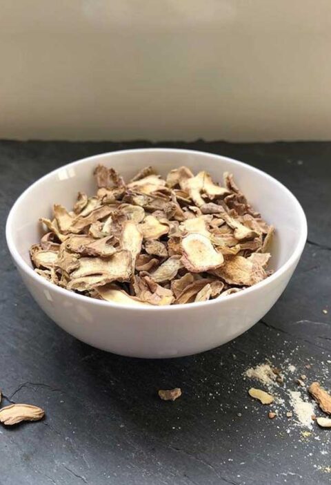 Een wit schaaltje met daarin gedroogde plakjes en stukjes gember.