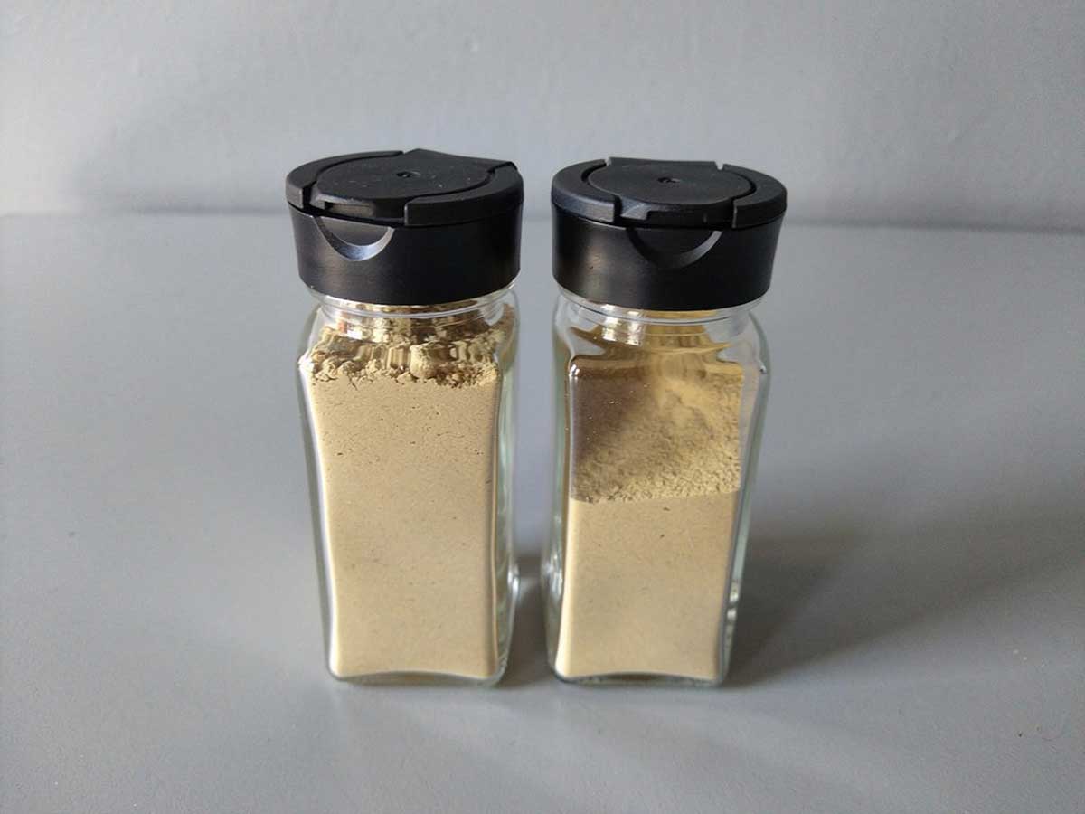 2 kruidenpotjes, helemaal tot bovenaan gevuld met zelfgemaakt gemberpoeder.