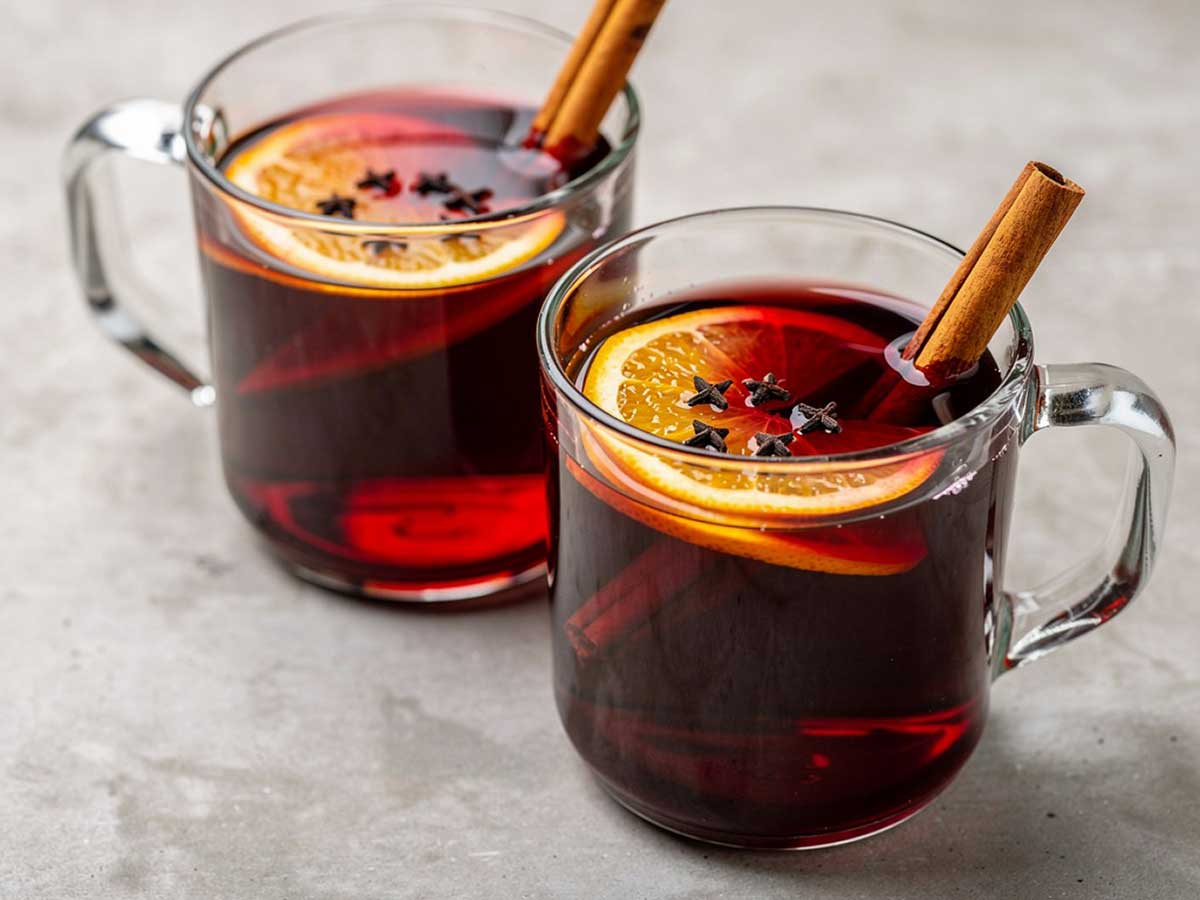 2 glazen met daarin glühwein met kaneel, citroen en meer.
