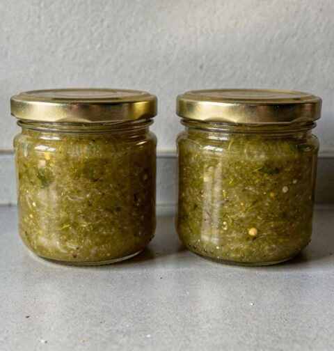 2 jampotten groene tomatenjam staan op het aanrecht.