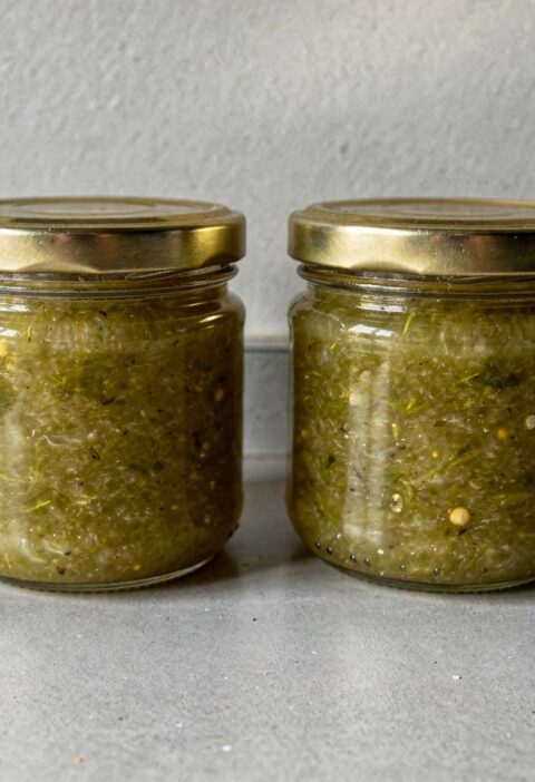 2 jampotten groene tomatenjam staan op het aanrecht.