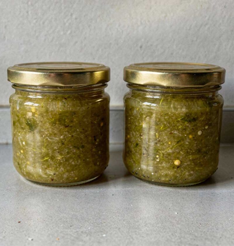 2 jampotten groene tomatenjam staan op het aanrecht.