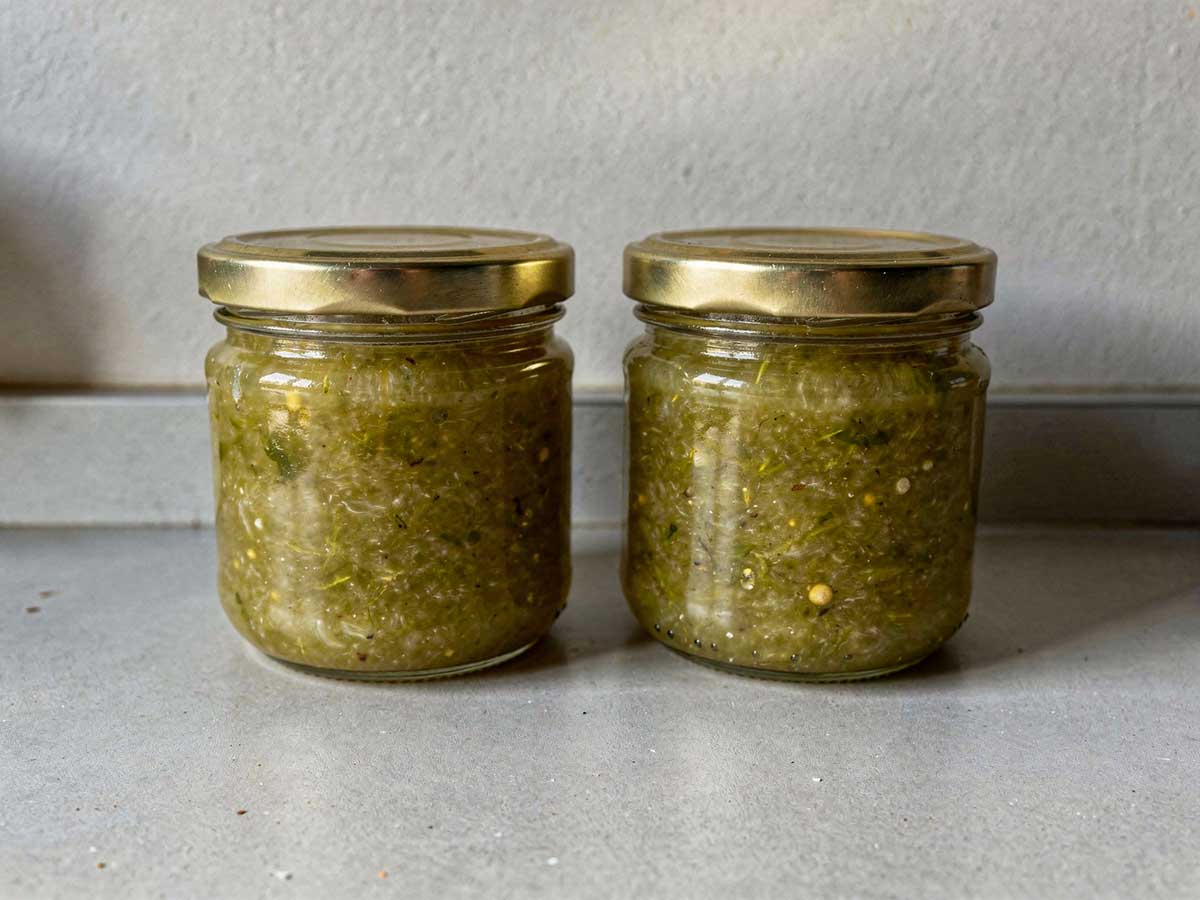 2 jampotten groene tomatenjam staan op het aanrecht.