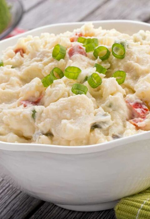 Een witte schaal met net gemaakte aardappelsalade om te bewaren.