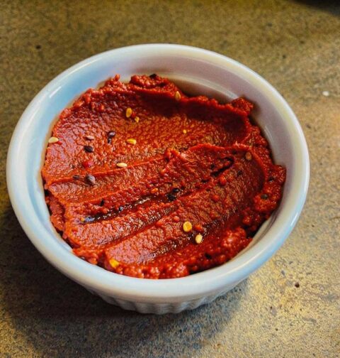 Een klein schaaltje met daarin zelfgemaakte harissa saus.