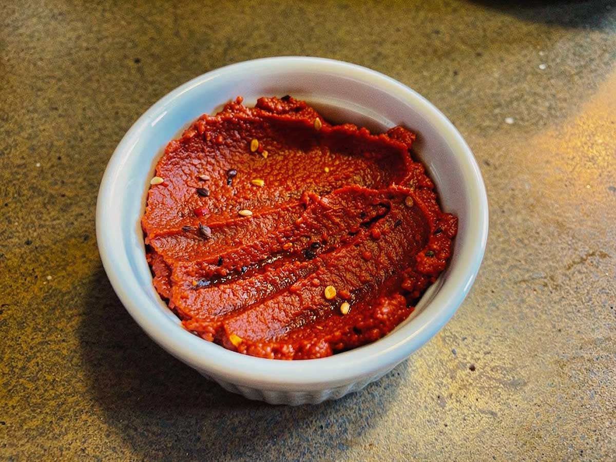 Een klein schaaltje met daarin zelfgemaakte harissa saus.