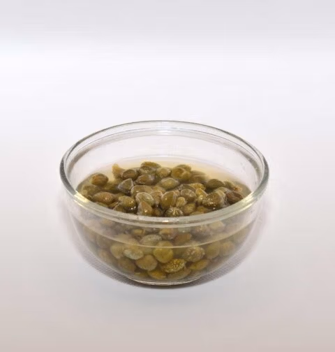 Ingemaakte kappertjes in een klein schaaltje, met inmaakvocht.