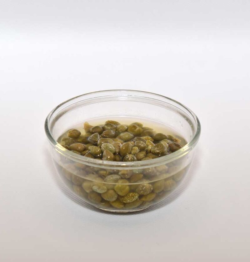 Ingemaakte kappertjes in een klein schaaltje, met inmaakvocht.