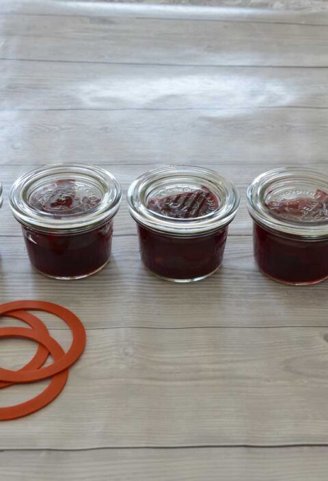 5 inmaakpotten gevulde met kersen, klaar om in te maken.