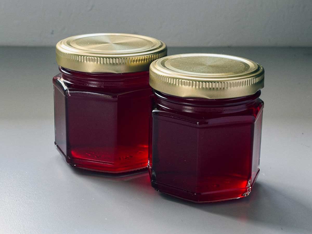 Twee jampotten gevulde met zelfgemaakte klaprozengelei.