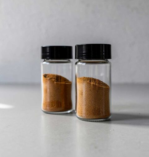Twee kruidenpotjes, gedeeltelijk gevuld emt Ras el hanout.