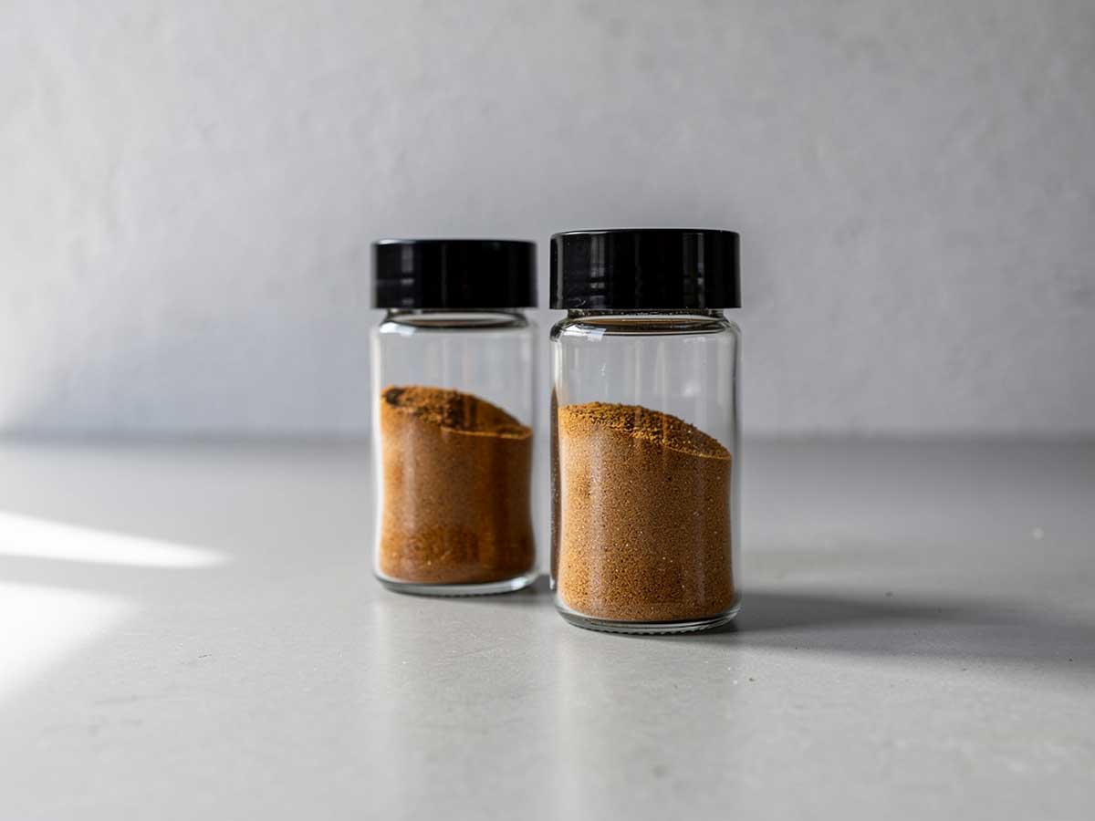 Twee kruidenpotjes, gedeeltelijk gevuld emt Ras el hanout.