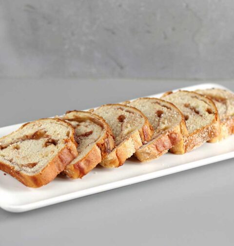 6 sneden suikerbrood op een witte platte schaal.