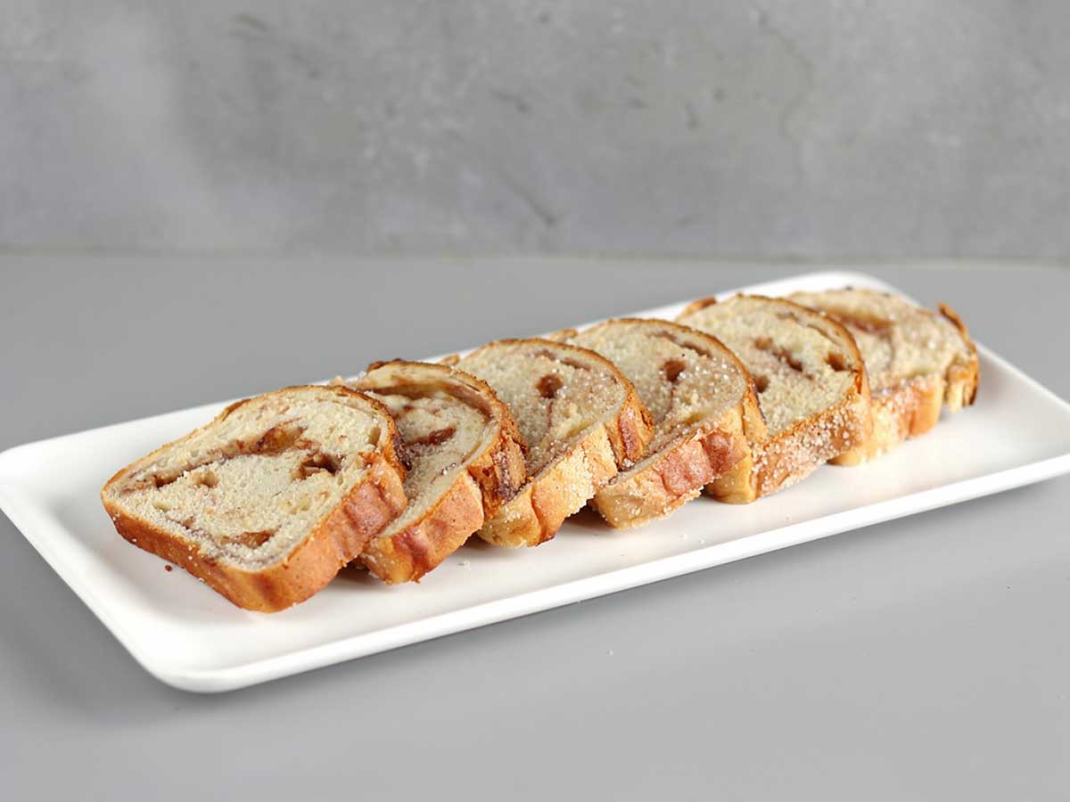 6 sneden suikerbrood op een witte platte schaal.