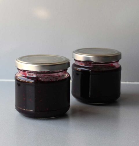 Twee kleine jampotje met daarin zelfgemaakte vlierbessenjam.