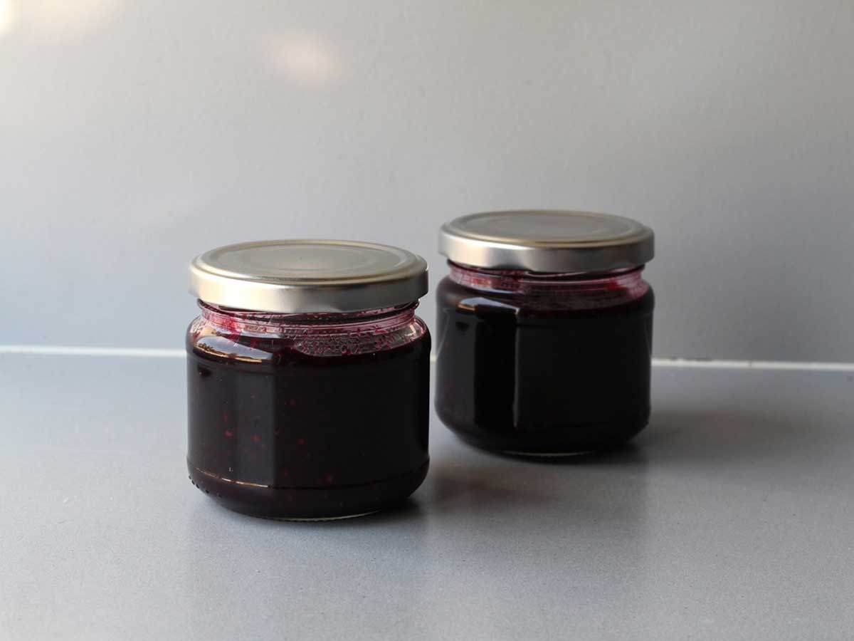Twee kleine jampotje met daarin zelfgemaakte vlierbessenjam.