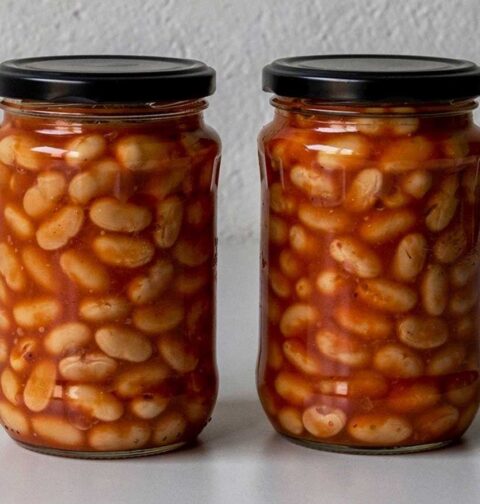 Twee grote potten geweckte witte bonen in tomatensaus.
