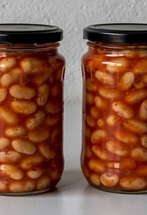 Twee grote potten geweckte witte bonen in tomatensaus.