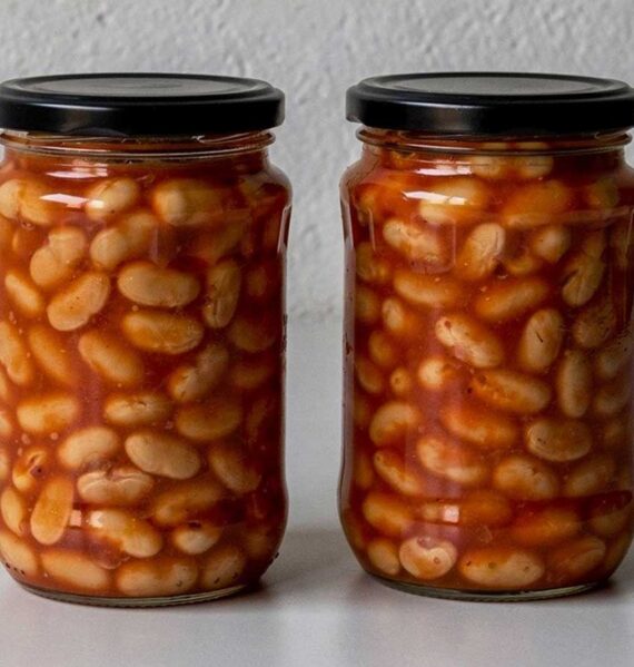 Twee grote potten geweckte witte bonen in tomatensaus.