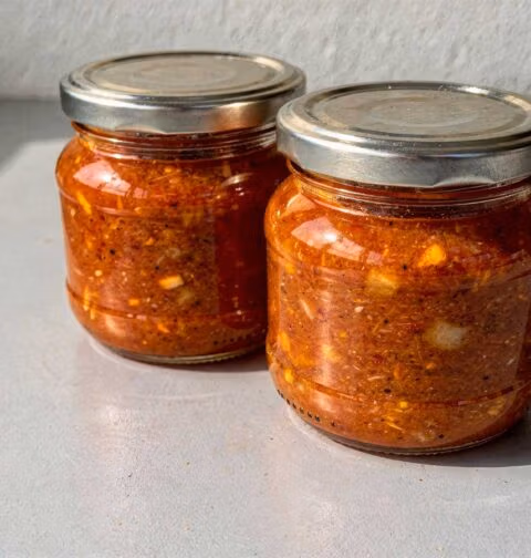 2 grote inmaakpotten met daarin mandarijn tomaten chutney.